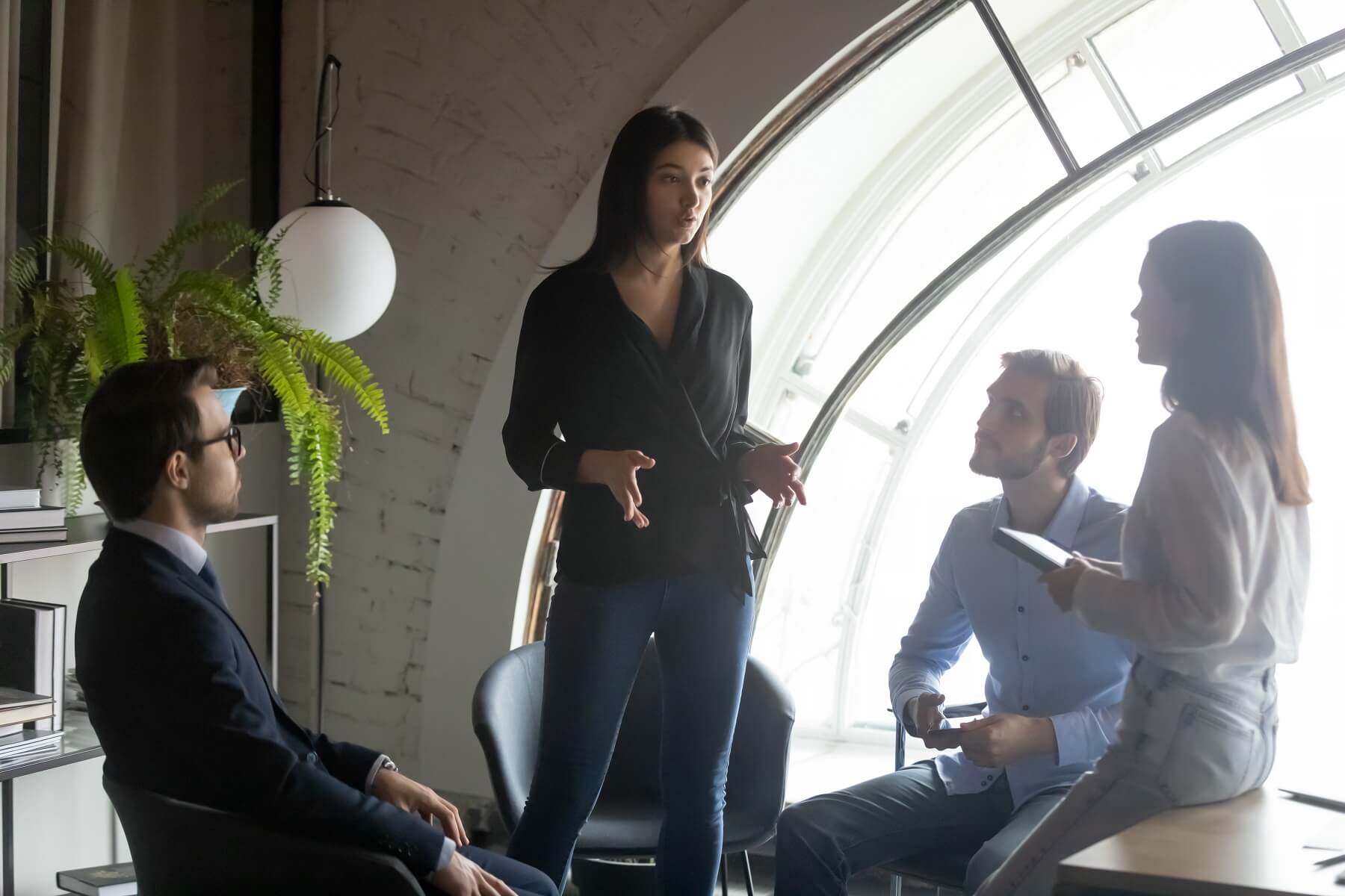 Confident Indian businesswoman mentor leading briefing, giving instructions to diverse employees team, colleagues business partners discussing project strategy, sitting in circle, listening to coach